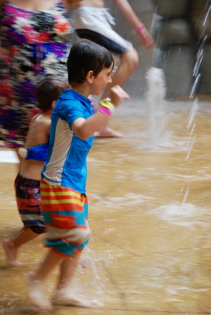boy running in splash pad