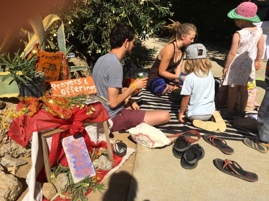 children and adults giving prayers and offerings - Finding Your Alternate Universe at Shakti Fest