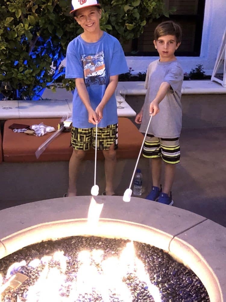 two boys roasting marshmallows over fire pit - Hyatt Regency Westlake staycation fire pit