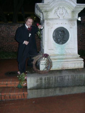 Edgar Allan Poe standing next to statue Baltimore Walking Tour with Teens - gravesite - Best Tour With Teens in Baltimore: The Poe Trail