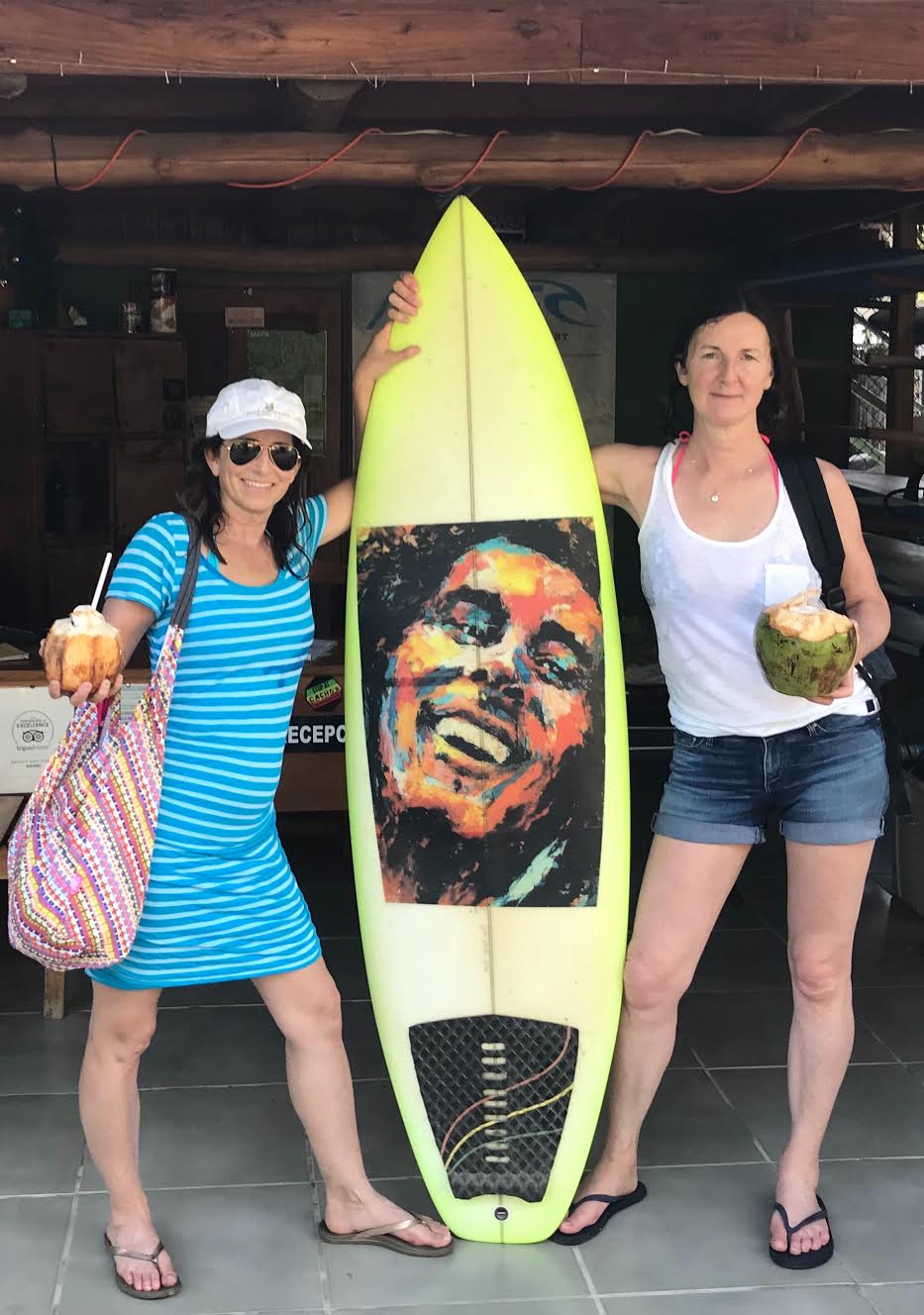 women with bob marley surf board - 7 Tips for Traveling with Girlfriends