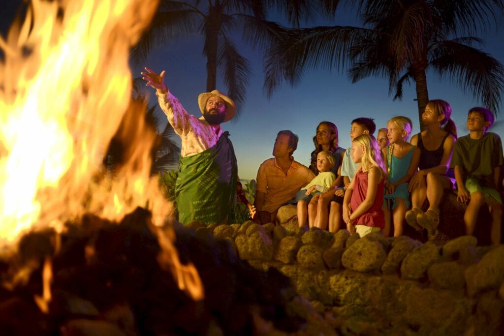 Man sharinng story to people around a fire - Behind the Scenes at Disney: An Invitation to Explore