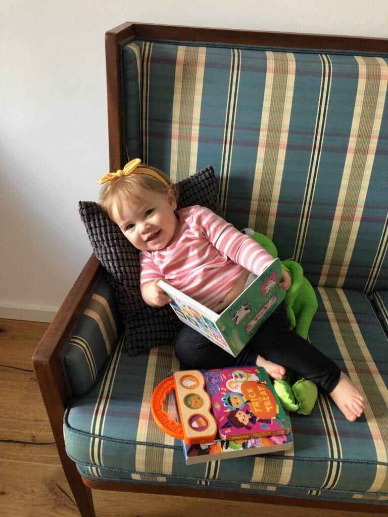 Baby reading book in chair - How to Survive a Vacation in Europe with a Baby