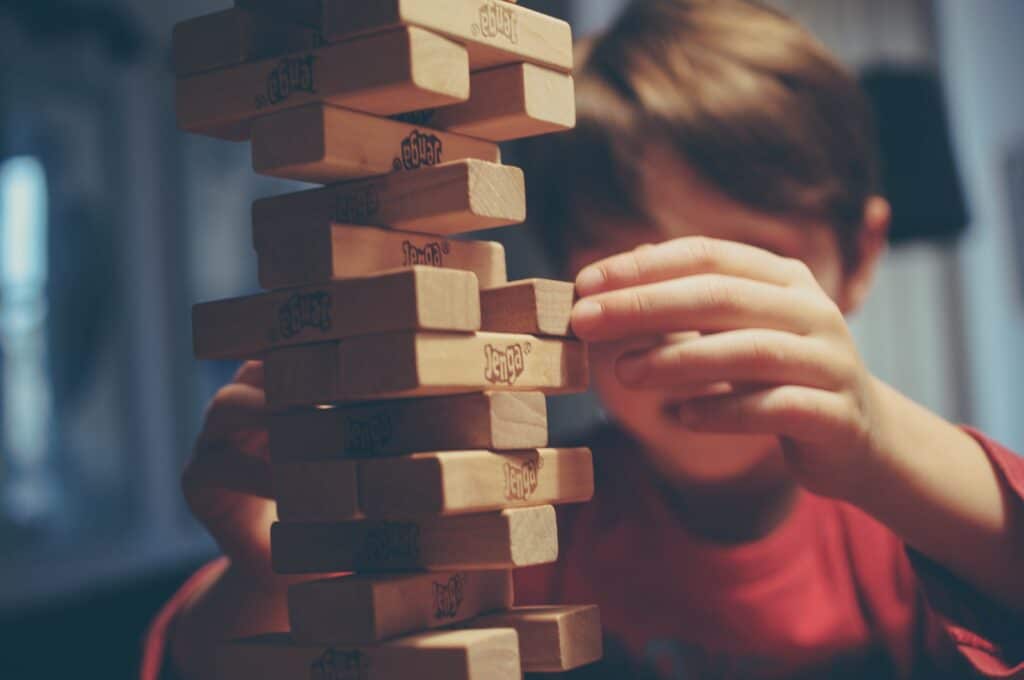 Boy playing JEnga - 9 Tips to Plan Your Family Trip After Quarantine Now!