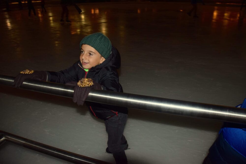 boy in ice rink holding on to rail - Fun with Kids in Vail Colorado