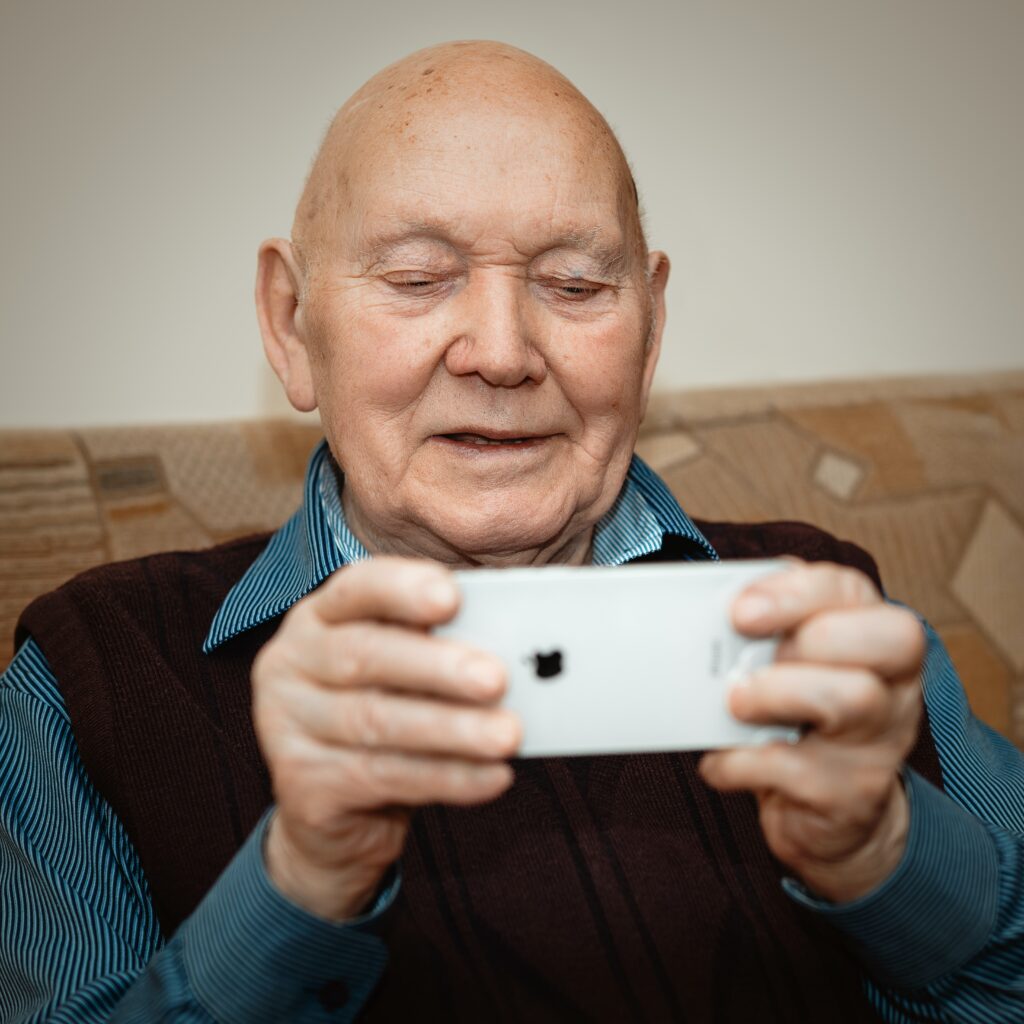 Older man on his phone - Travel In Time: Tips to Help the Elderly Cope with Coronavirus