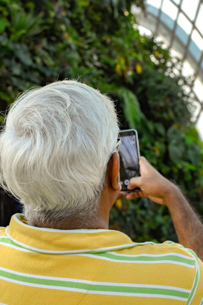 Man taking photo on his phone - Travel In Time: Tips to Help the Elderly Cope with Coronavirus