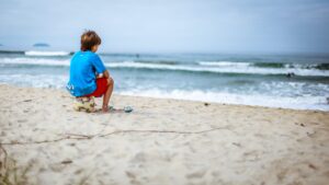 boy with soccer ball on the beach