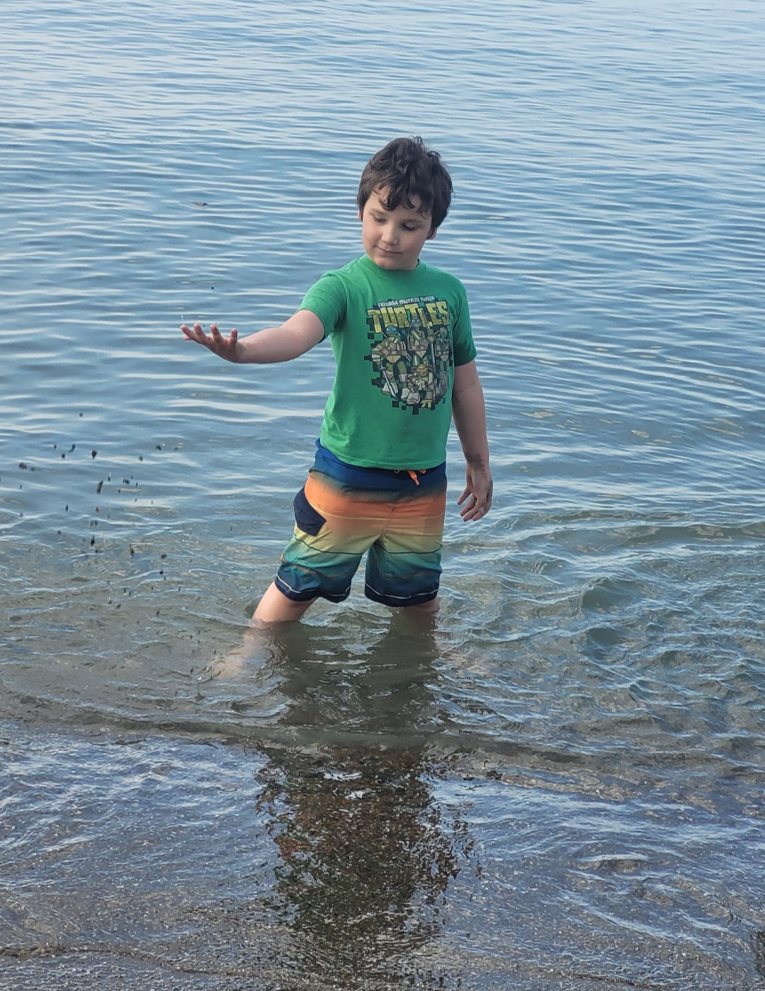 Boy standing playing with sand in front of Lake Erie. Best things to do in Cleveland with kids. 