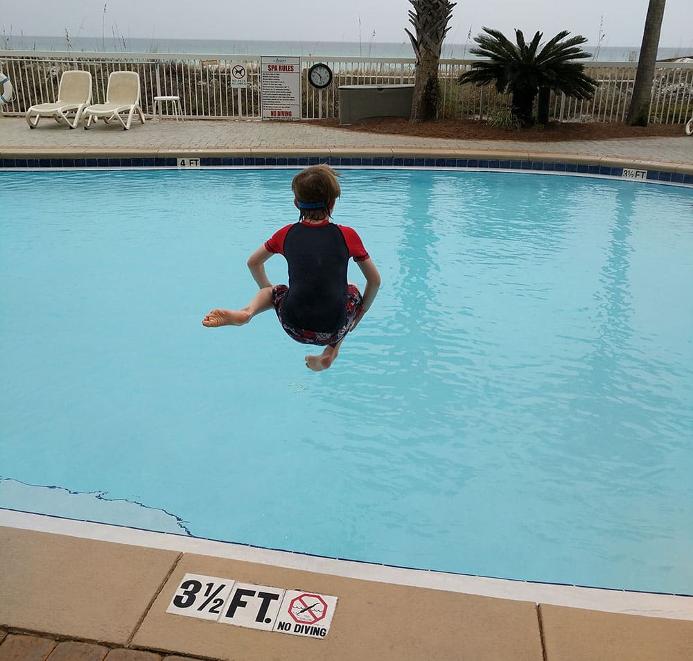 Boy jumping into pool - Four Spots on the Gulf Coast for A Low-Key Family Vacation