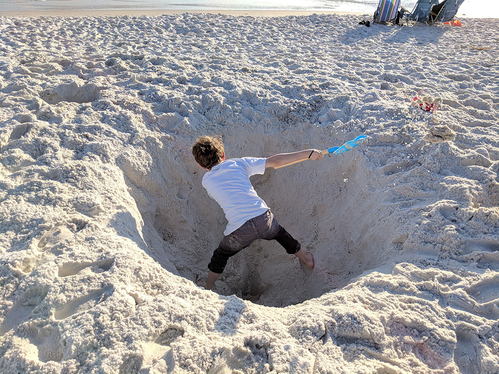 Boy digging in the sand - Four Spots on the Gulf Coast for A Low-Key Family Vacation