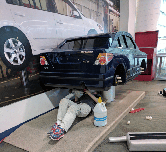 kid under car fixing it - Best museums in Nashville for Kids