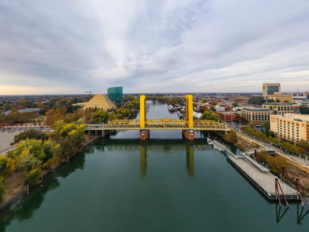 View of the Sacramento River with the Tower Bridge and other buildings in the distance. Things to do with kids in Sacramento