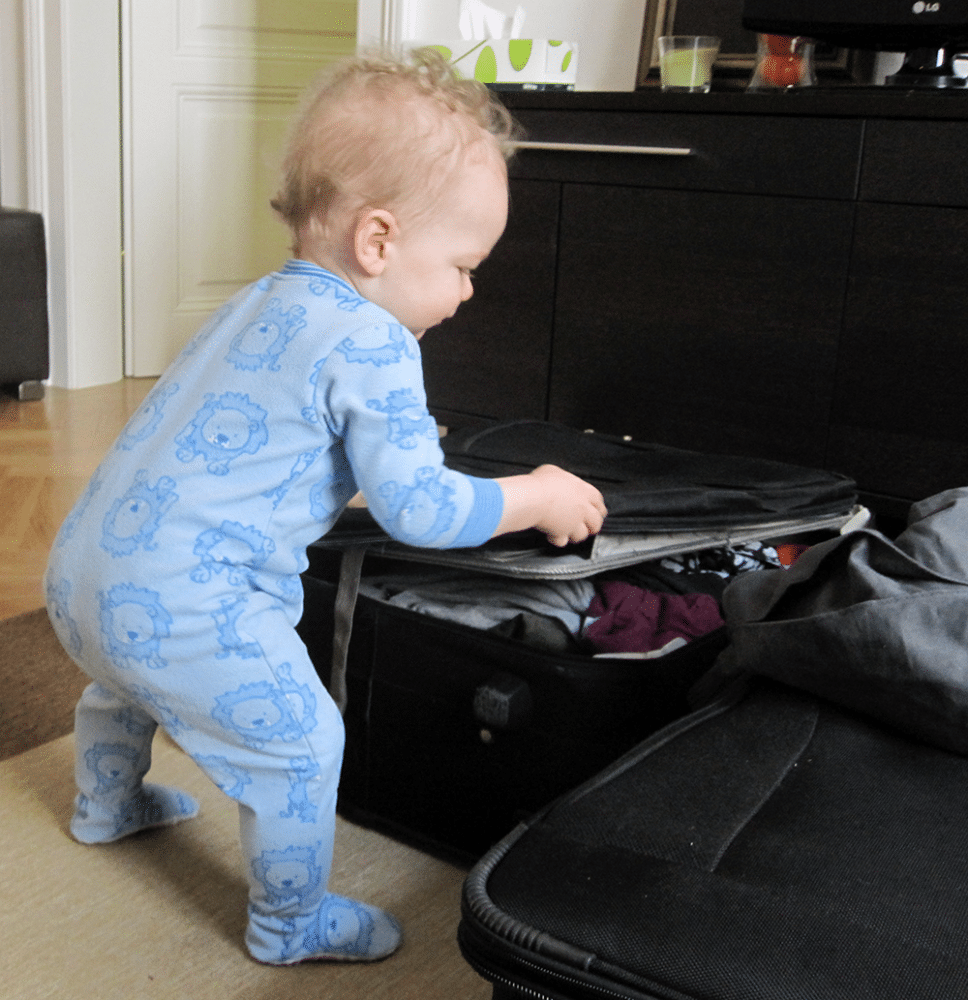 toddler going into suitcase - travel hacks for babies