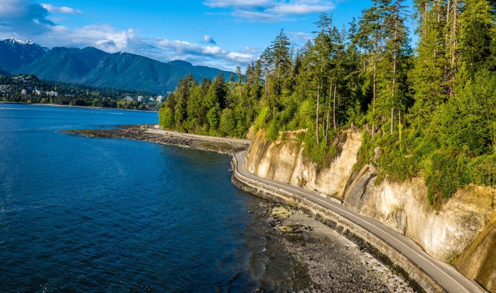 Aerial view of the Stanley Park seawall, coniferous terrain on one side and the ocean on the other. vancouver with kids how to spend the best long weekend family travel