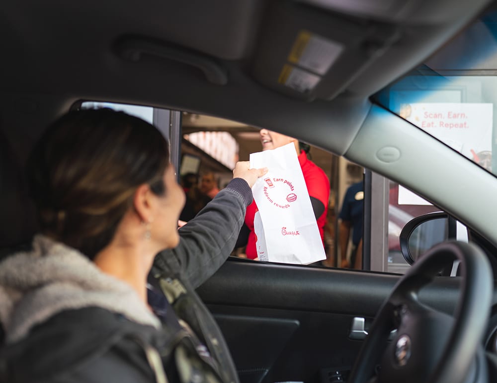 A mom gets drive-thru fast food for a quick meal. Travel hacks for moms.