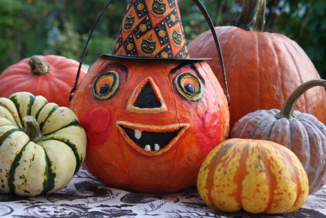A pumpkin with a painted face and witch's hat, surrounded by other pumpkins.Fall in Denver: The Best 5 Things to do With Kids family travel halloween