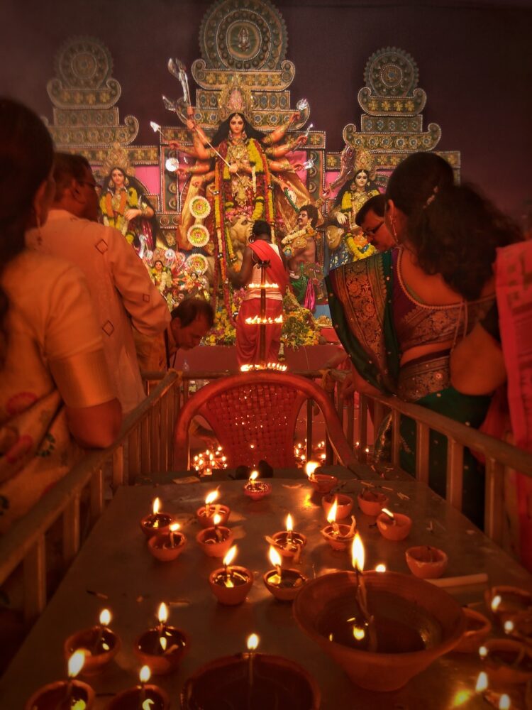 Individuals pray to a Hindu goddess in a temple. Diwali enjoying with kids festival of lights family travel