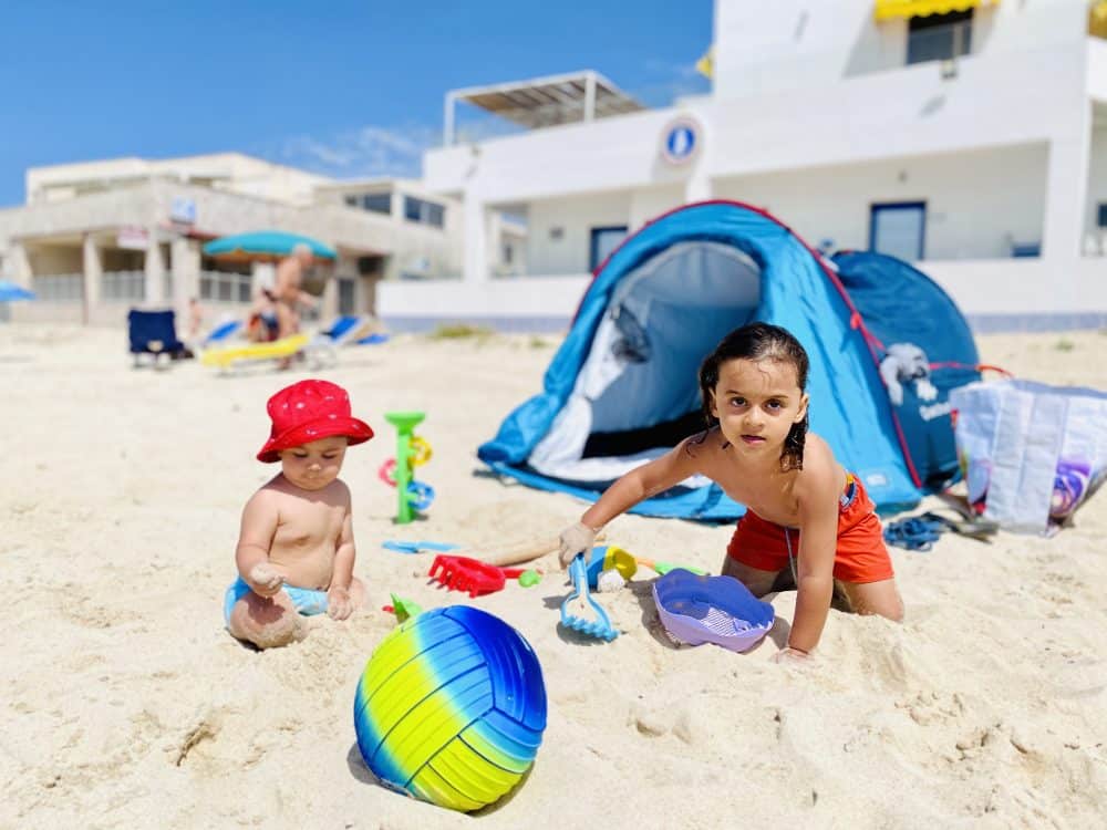 My boys are enjoying their beach toys in front of our tent - best Salento beaches