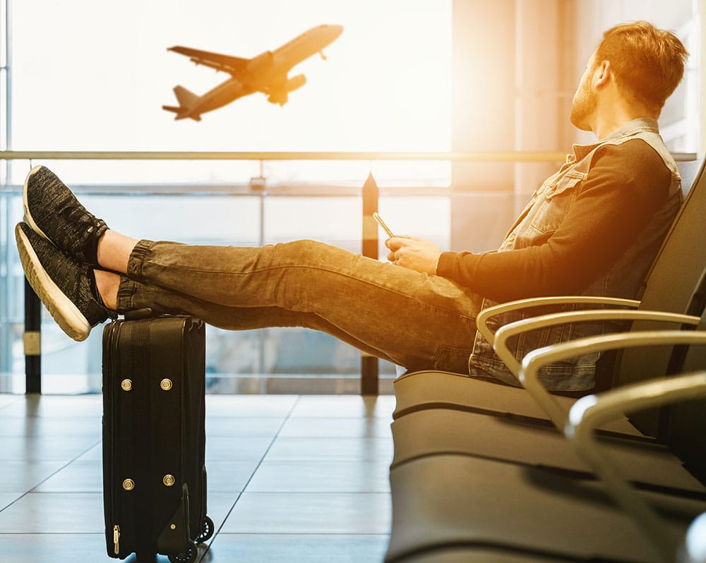 A frequent traveler rests in airport seating. Airport lounge access is a great gift for the travelers in your life. 
