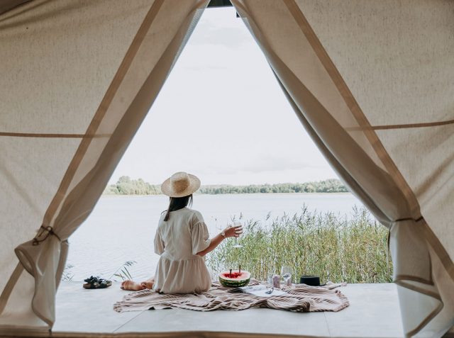 A girl glamping with a picnic and a canvas tent. Tentrr gift cards for glamping are good last-minute gifts. 