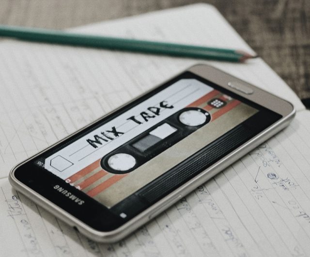 A phone with a lock screen that's a picture of a cassette that says says "Mix Tape." 