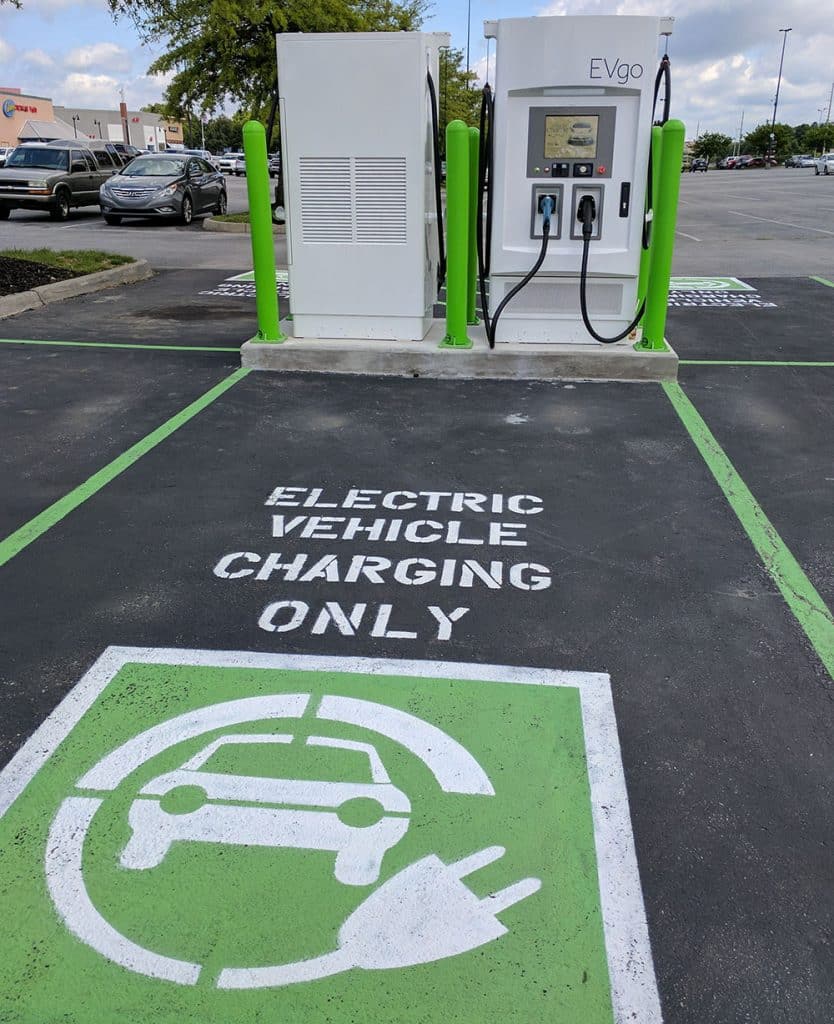 An electric vehicle charger with a parking space that says Electric Vehicle Charging Only - Tips for Taking a Family Road Trip with an Electric Vehicle