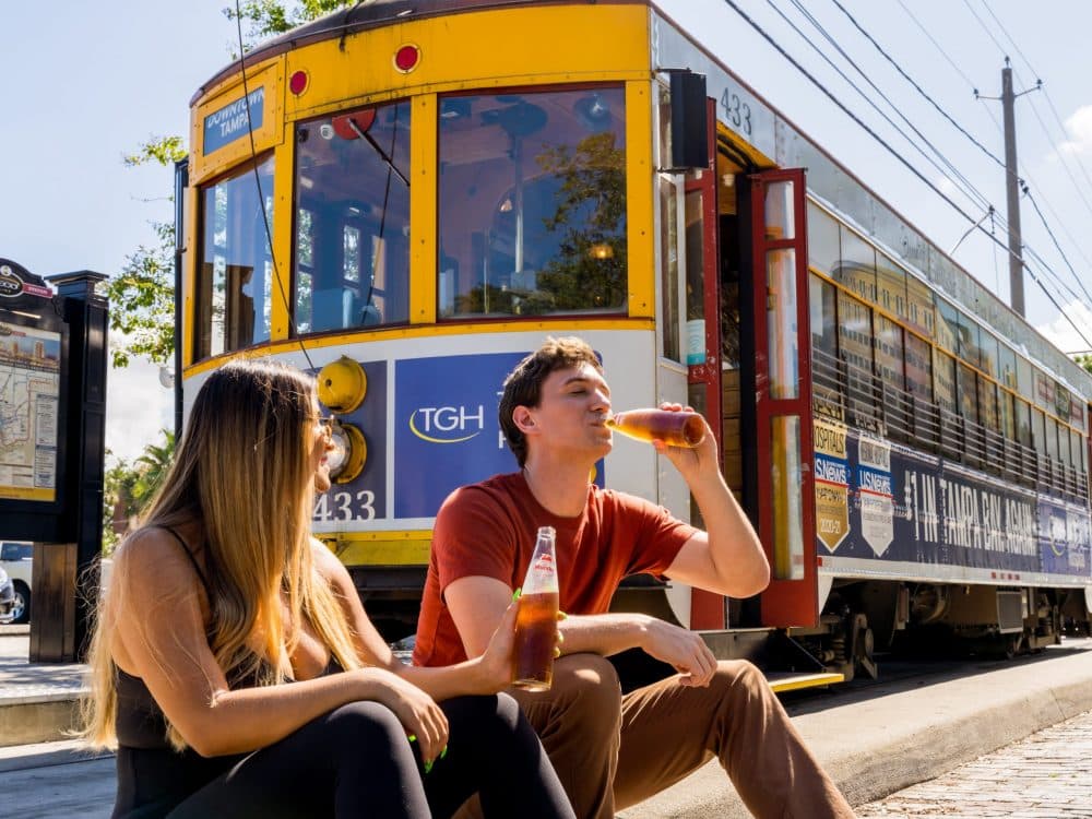 teens drinking soda in front of a trolley