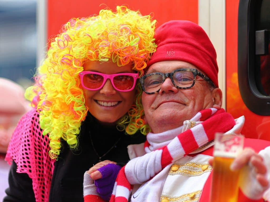 Merry Couple with woman wearing yellow wig and man wearing Waldo outfit.// Best Carnival Locations in Europe or Families.
