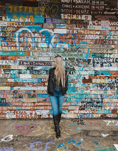 A woman stands in front of a graffiti-covered building at Anderson Dock in romantic Door County, Wisconsin. 