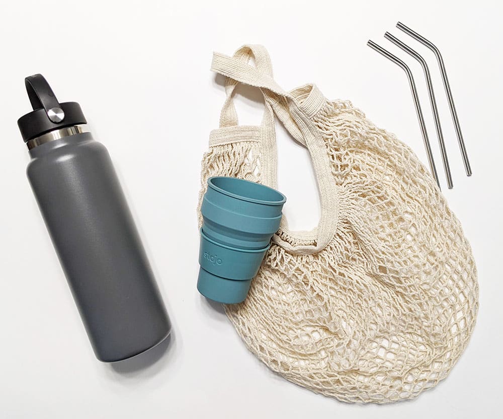 Earth day travel tip: Reusable water bottle, cloth bag, metal straws, and collapsible coffee cup