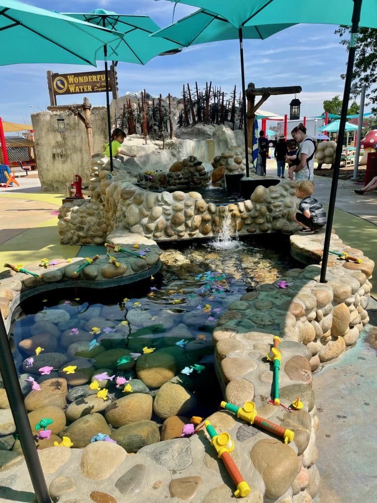 outdoor river with plastic fish and fishing poles - things to do in visalia