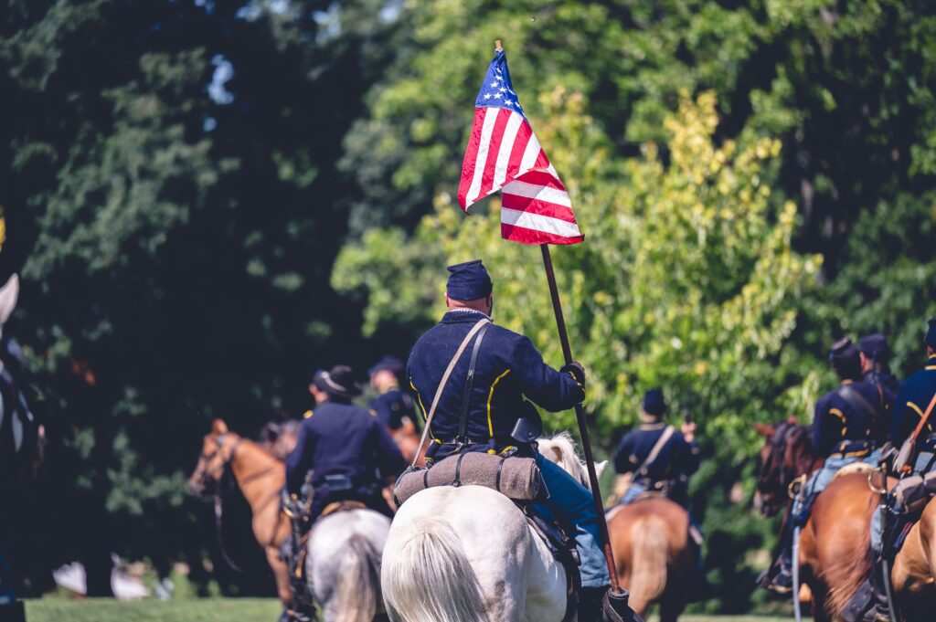 union soldiers on horseback holding flag in parade