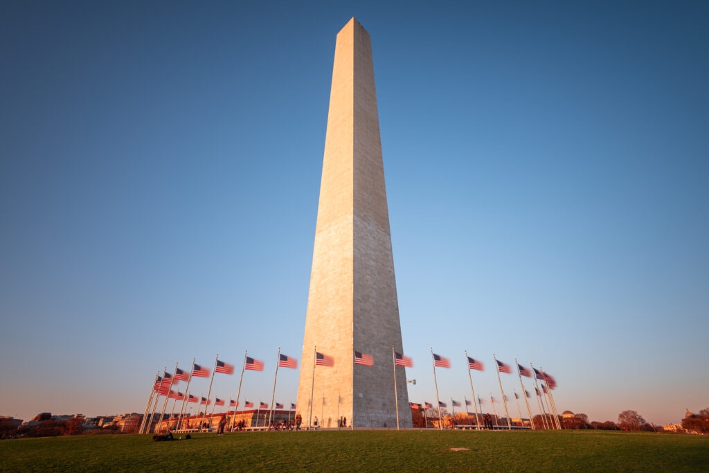 american flags surrounding Washington Monument during sunset