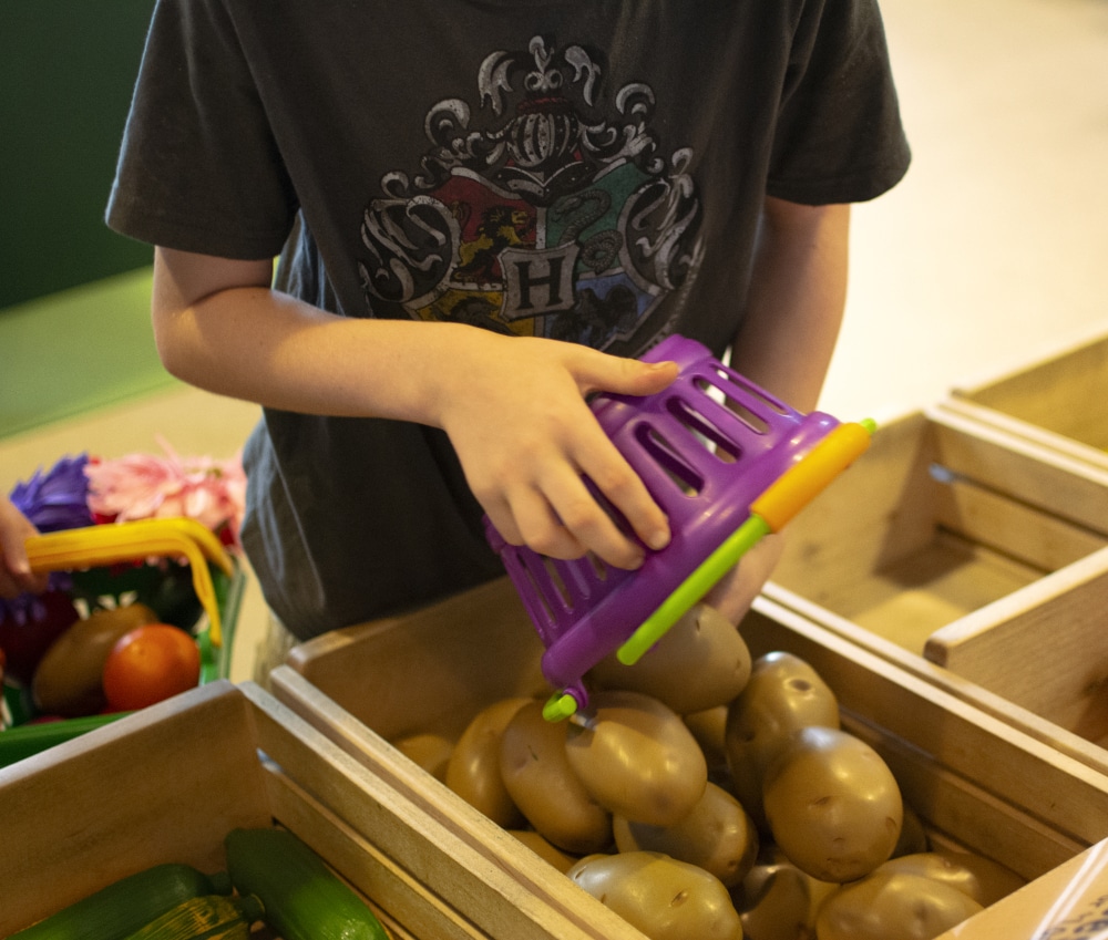 A child plays with plastic produce in the kids' area of the Perot Museum in Dallas. 