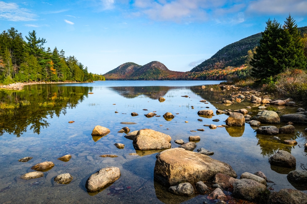 mountains reflected in lake - best fall vacations in the usa
