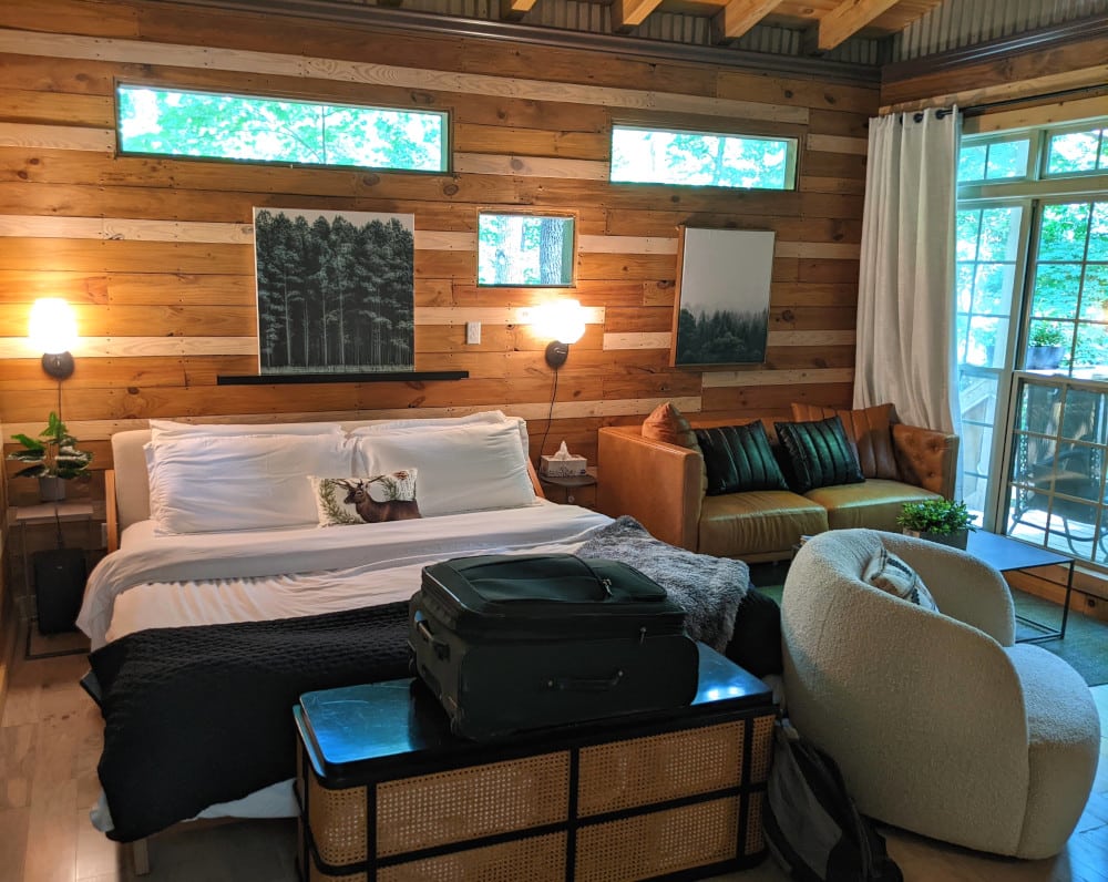 Rustic wood paneling with a modern, comfortable bed in a Terralodge Treehouse