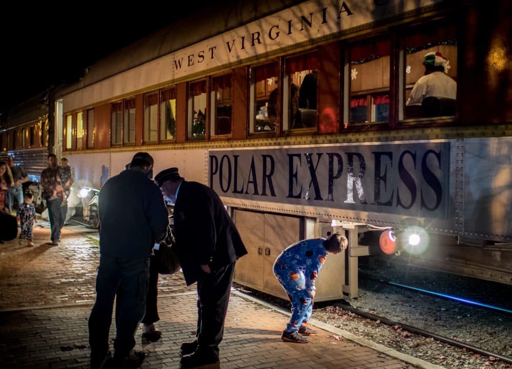 Boy in pajamas looking at Polar Express Train - Christmas Family Bucket List