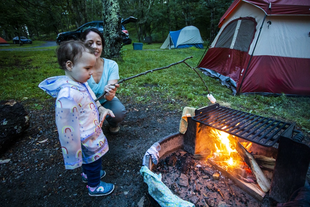 Family camping experience in Shenandoah National Park during autumn with colorful fall foliage surrounding the campsite