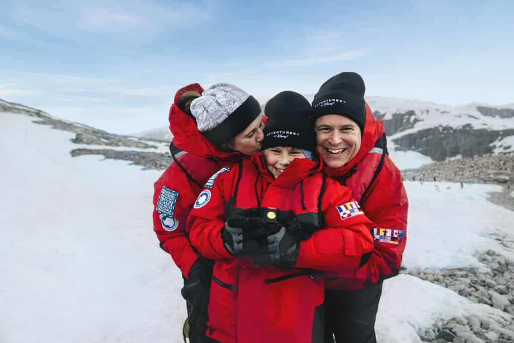 two parents hugging teen - Adventures by Disney Antarctica