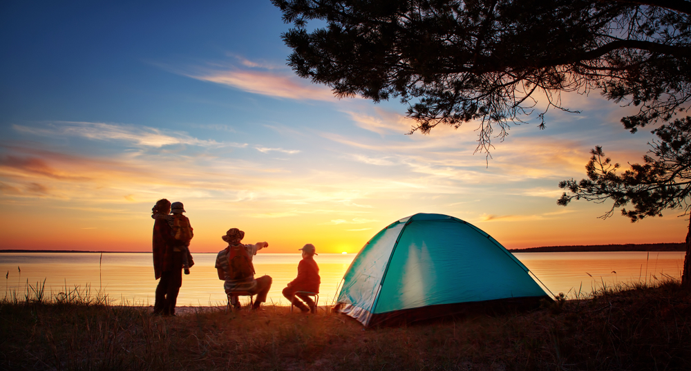 Family Camping and watching sunset over lake.