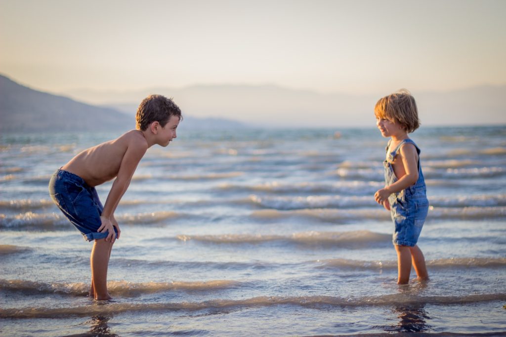 two kids in ocean - best places to stay in los angeles for families