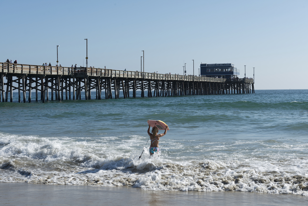 Newport Pier Beach With child boogie boarding - Best California Beaches for Families