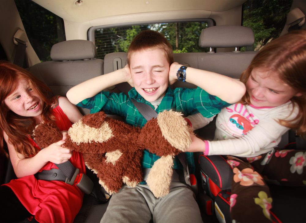 Kids fighting over stuffed ape. Boy closing his ear in middle. BEST TRAVEL PILLOWS FOR KIDS