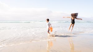 Photos of kids playing in the ocean at the beach