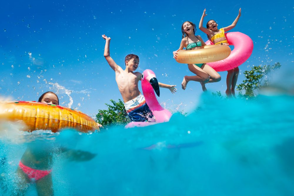 Kids jumping into pool - Vacation Spots for Teens in the U.S.