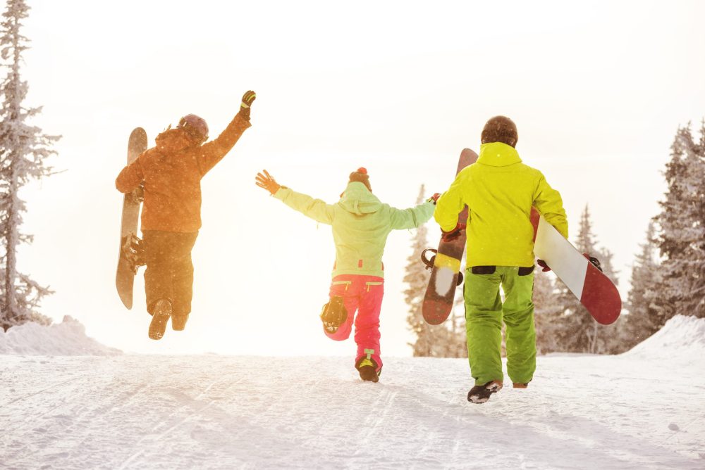 three young skiers jumping for joy - Vacation Spots for Teens in the U.S.
