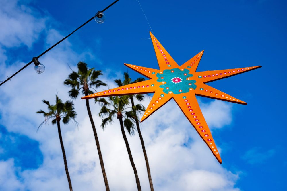 San Diego sky at Christmas- Bright blue with puffy white clouds interuptted by a shining gold Christmas star.