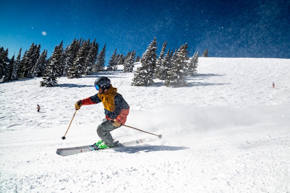 Photo of skier going down mountain slopes at ski resort