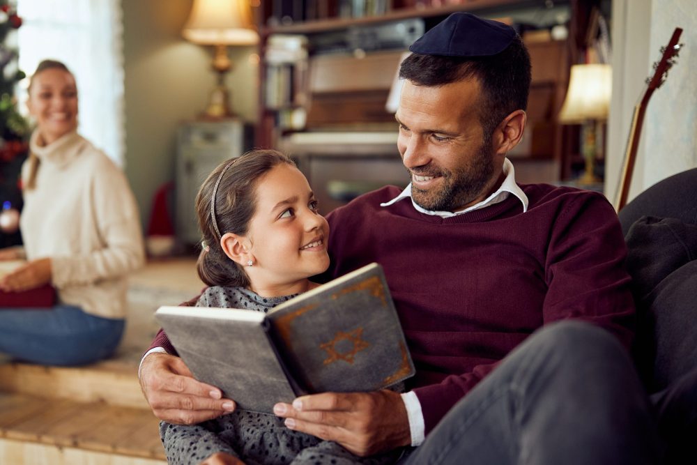 a father and daughter share a book in a cozy setting
